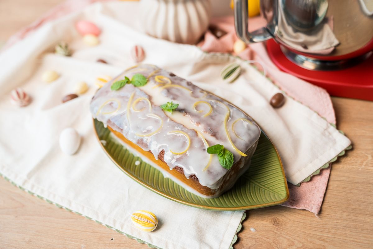 Elegantni limun kolač s glazurom ukrašen mentom i limunovom koricom