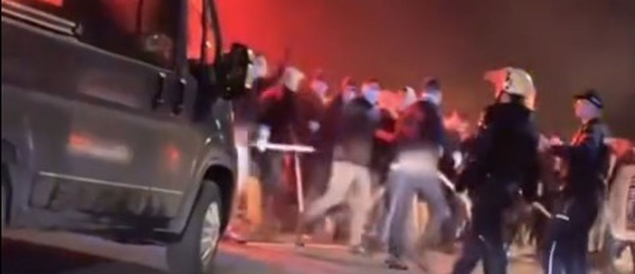 Huligani s palicama prolaze pokraj policije