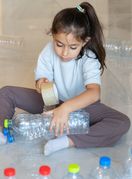 Dijete se igra s plastičnim bocama