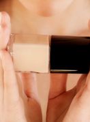 Žena drži bočicu tekućeg pudera