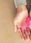 Ženske ruke drže ružičastu vrpcu, simbol borbe protiv raka dojke