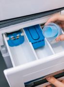 Žena stavlja omekšivač u perilicu rublja