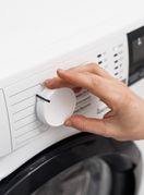 Žena namješta perilicu rublja