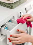 Žena čisti pretinac za deterdžent perilice rublja