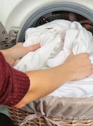 Žena vadi oprano rublje iz perilice