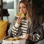 Tužna djevojka jede pizzu