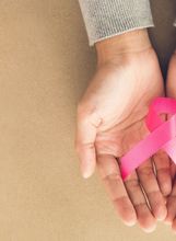 Ženske ruke drže ružičastu vrpcu, simbol borbe protiv raka dojke