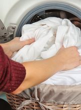 Žena vadi oprano rublje iz perilice