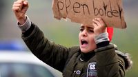 Migranti drže plakate