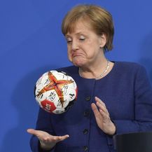 Angela Merkel s rukometnom loptom potpisane od strane njemačke rukometne reprezentacije
