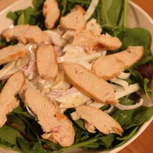 Na sitnu lisnatu salatu stavite waldrofsku salatu i poslažite piletinu narezanu na ploškice
