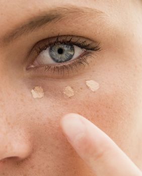 Žena nanosi korektor