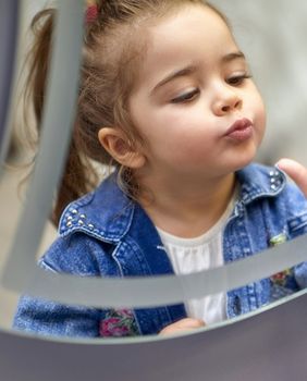 Djevojčica se gleda u ogledalo