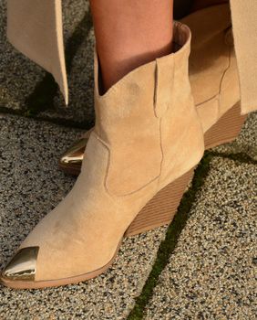 Žena u gležnjačama od brušene kože