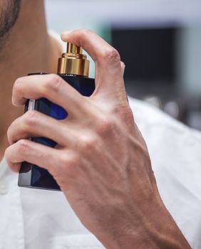 Muškarac nanosi parfem
