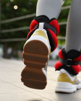 Žena hoda s utezima oko gležnjeva