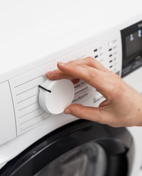 Žena namješta perilicu rublja