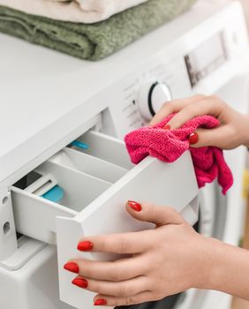 Žena čisti pretinac za deterdžent perilice rublja