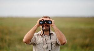 Muškarac koji gleda kroz dvogled