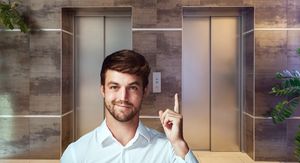 Dizalo u zgradi i muškarac koji pokazuje prema gore