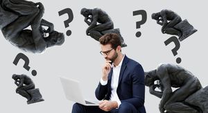 Muškarac koji razmišlja pred računalom i kip mislioca