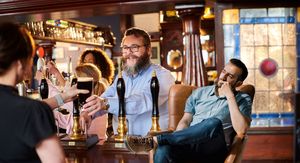 Konobara u Pubu kako toči piće i muškarac koji razmišlja