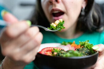 Žena jede vegansku salatu