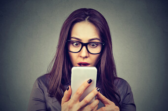 Šokirana žena gleda u telefon, ilustracija