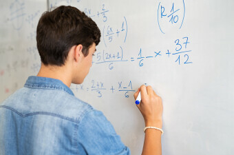 Učenik rješava matematički zadatak na ploči, ilustracija