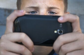 Dječak se igra na mobilnom telefonu, ilustracija