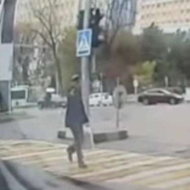 Starac koji prelazi cestu s pištoljem u ruci