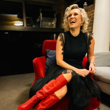 Vanna u crnoj haljini i crvenim čizmama