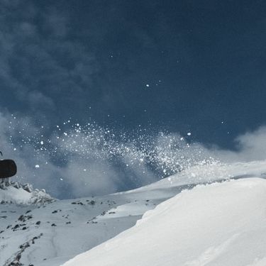 Snowboarder u letu kako izvodi trik