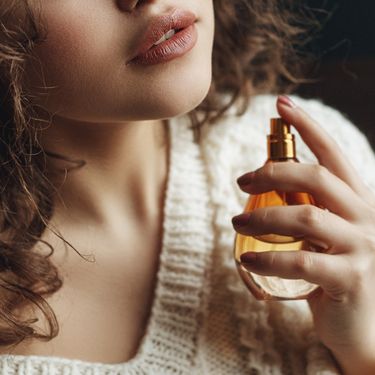 Žena i bočica parfema