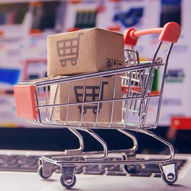 Kolica za kupnju puna paketa i laptop s otvorenom stranicom za kupnju