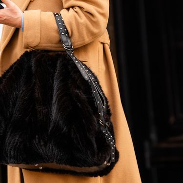 Žena nosi krznenu torbu