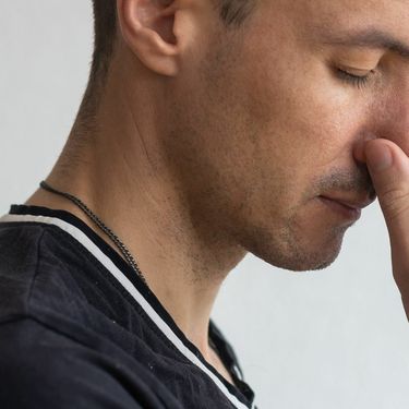 Muškarac koji se drži za nos