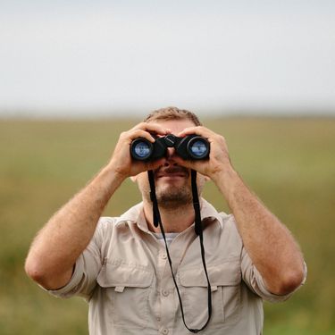 Muškarac koji gleda kroz dvogled