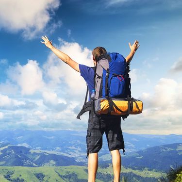 Muškarac s raširenim rukama kako gleda prema horizontu