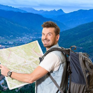 Grad u planinama i turist s ruksakom i kartom