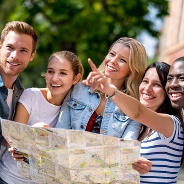 Razni turisti koji gledaju na kartu