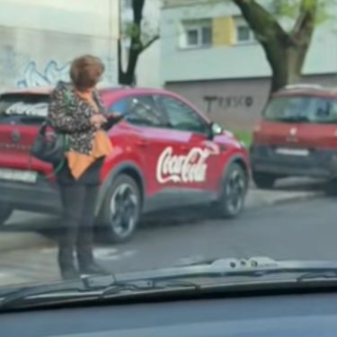 Gospođa na mobitelu nasred pješačkog prijelaza