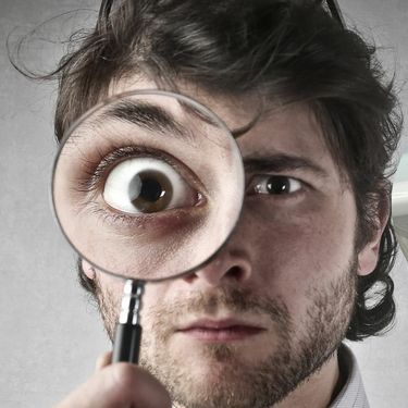 Muškarac koji gleda kroz povećalo i izazov traženja