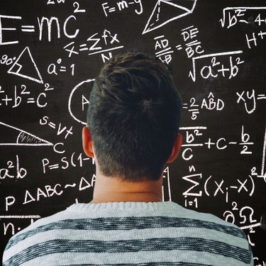 Muškarac kako razmišlja ispred ploče s matematičkim formulama