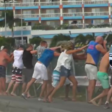 Mlažnjak pri polijetanju i turisti koji se drže za ogradu