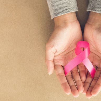 Ženske ruke drže ružičastu vrpcu, simbol borbe protiv raka dojke