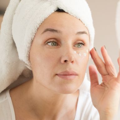 Žena nanosi kremu za područje oko očiju