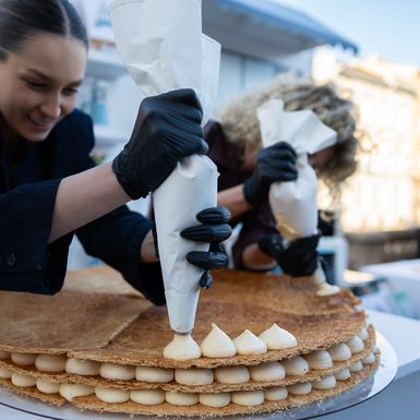 Erika i Eni dovršavaju mille-feuille tortu ispred posjetitelja festivala Jesi za tortu?