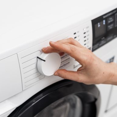 Žena namješta perilicu rublja