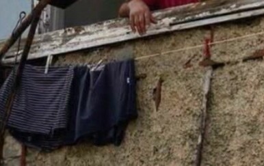 Muškarac na prozoru kako peče roštilj